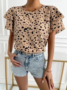 Detail shot of women's short-sleeve printed polka dot top, casual summer fashion style.