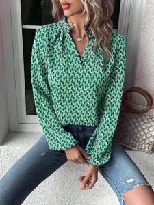 Detailed shot showing the green print pattern, V-neck pleated collar, and lantern sleeves.