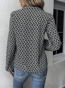 Detailed back view of women's black and white patterned lantern sleeve blouse shirt.