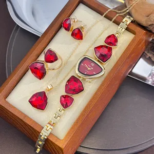 Detail shot of the triangular red crystal jewelry set including necklace, earrings, and watch.