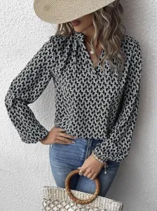 Close-up detail of the elegant black and white geometric print long sleeve blouse.