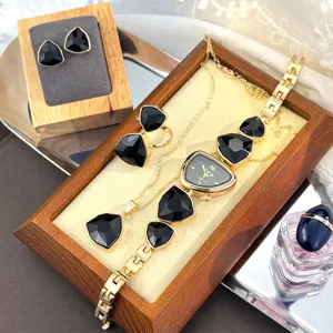 Elegant irregular watch four-piece set with striking black geometric stones and gold-tone finish for women.