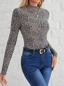 Close-up of women's long sleeve mock neck leopard print top paired with blue jeans.
