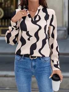 Stylish abstract print V-neck long sleeve blouse detail, paired with chic denim jeans.