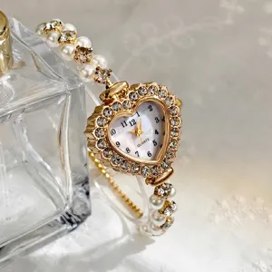 Herzförmige Strass-Quarzuhr mit zweireihigem Perlenarmband Detailansicht präsentieren.