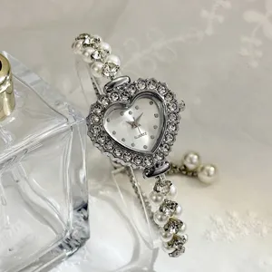 Detailansicht Damen Mode Herz Strass Perle Quarz Armbanduhr elegantes Design stilvoll.