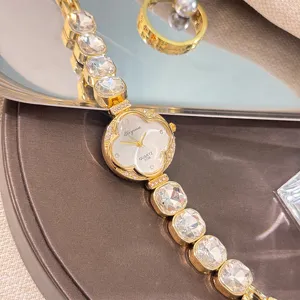 Vista detallada del reloj de cuarzo trébol con estrás, elegante diseño de pulsera dorada brillante.