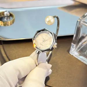 Elegante reloj de cuarzo para mujer con esfera de cristal hexagonal y brazalete.