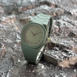 Grüne Herren Plastik Quarz Armbanduhr mit arabischen Ziffern und achteckiger Lünette.