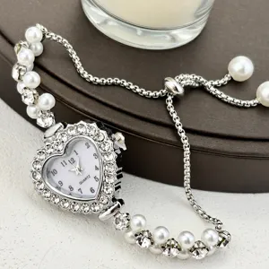 Herzförmige Strass-Quarzuhr mit doppeltem Perlenarmband, stilvolles Detailfoto.