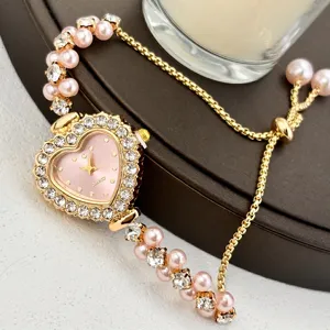 Herzfoermige Damen Quarz Armbanduhr mit Strasssteinen und rosa Perlenkette, elegant.