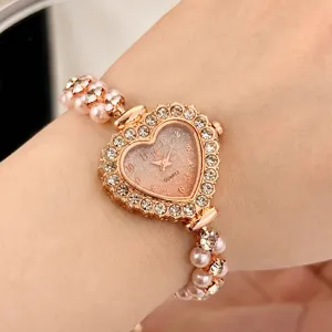 Detailansicht der Damen Herz Strass Quarzuhr mit elegantem doppelten Perlenarmband.