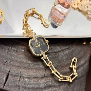 Primo piano sui dettagli del lusinghiero orologio al quarzo dorato con quadrante sfaccettato.