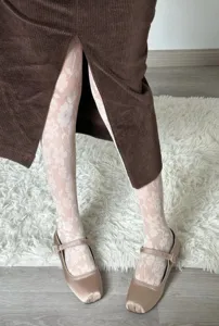 White sheer floral jacquard pantyhose detail shot, elegant translucent patterned tights.