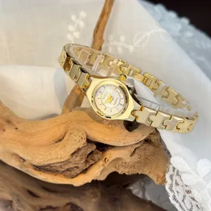 Exquisite small gold quartz watch with unique linked strap, elegant minimalist design for women.
