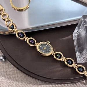 Primo piano dettagliato di orologio da donna al quarzo dorato con quadrante ovale e cinturino.