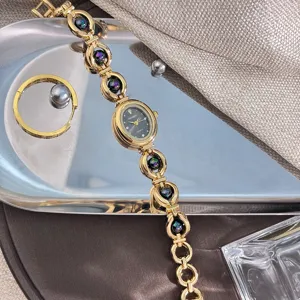 Vista dettagliata del bracciale con orologio al quarzo dorato con quadrante ovale nero.