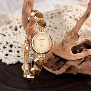 Nahaufnahme einer Vintage Quarzuhr mit Tigerauge Perlen und goldfarbenem Kettenarmband.