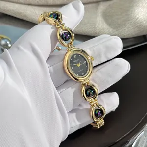 Orologio al quarzo vintage da donna con quadrante ovale e bracciale dorato con perle.