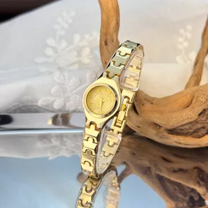 Elegant minimalist gold quartz watch for women with unique puzzle link bracelet and small dial.