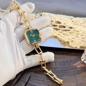Orologio al quarzo da donna con catena a maglie dorate e quadrante quadrato verde sfaccettato.