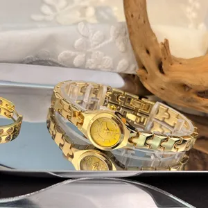 Delicate gold quartz watch with unique puzzle link strap and small dial, detail view.