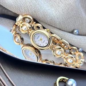 Orologio al quarzo ovale vintage da donna con bracciale a catena dorata e perle finte.