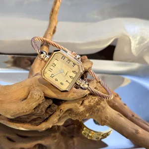 Nahaufnahme Detailansicht einer luxuriösen Quarz Armreif Uhr mit gedrehtem Armband und Zifferblatt.