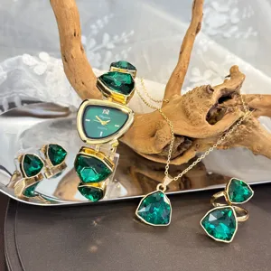 Detailed shot of irregular green crystal jewelry set including watch, necklace, and ring.