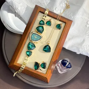 Irregular green crystal watch necklace ring earrings four-piece set, luxury metallic jewelry detail.