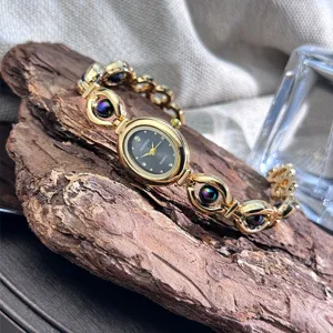 Primo piano dettagliato dell'orologio da polso dorato da donna con quadrante ovale.
