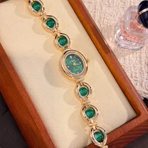Primo piano dettagliato dell'orologio al quarzo con quadrante verde e cinturino dorato.