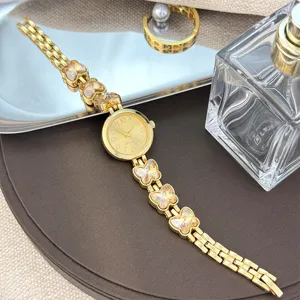 Elegante goldene Quarzuhr mit filigranen Schmetterling-Kristallgliedern als Armband.