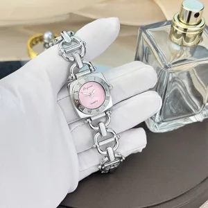 Detailansicht quadratische Damenuhr mit rosa Zifferblatt und elegantem Metallkettenarmband.