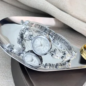 Silberne Quarzarmbanduhr Detail mit Kristallstein Gliedern, Zifferblatt und Metallarmband.