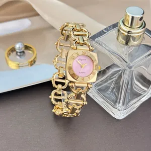 Nahaufnahme einer quadratischen Damen-Quarzuhr mit goldenem Gliederarmband und Deko.