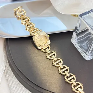 Detailansicht einer goldenen Damen-Quarzuhr mit quadratischem Zifferblatt und Kettengliederarmband.