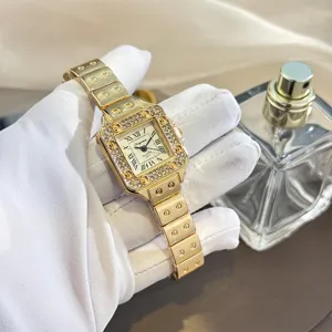 Detailaufnahme einer luxuriösen goldenen quadratischen Damenquarzuhr mit Strasslünette und Stahlarmband.