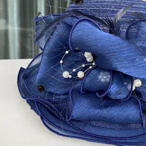 Detail van donkerblauwe zonnehoed met delicate organza volants, mesh sluier en parels.