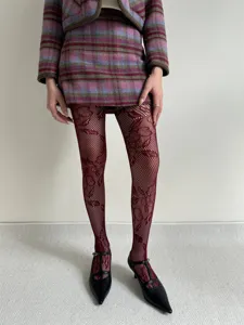Close-up detail of vintage floral fishnet tights paired with chic checkered outfit for women.