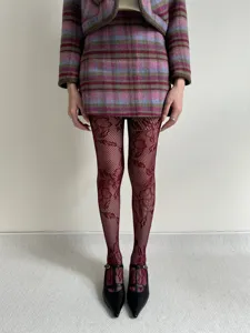 Women vintage plaid skirt suit and burgundy floral fishnet stockings fashion outfit detail shot.