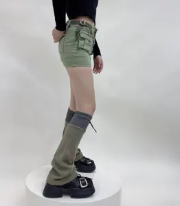 Detailed view of women's functional style patchwork leg warmers and cargo shorts outfit.