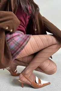 Detailed shot of women's patterned tights featuring chic hollow-out diagonal stripes for autumn.