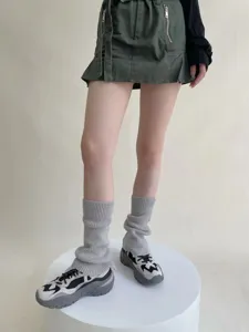 Calentadores de punto grises combinados con falda cargo y zapatillas para invierno.