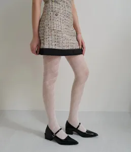 Detail shot of stylish patterned tights featuring a chic diagonal openwork jacquard design.