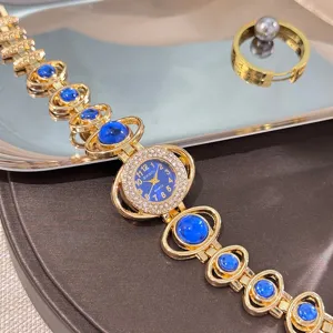 Women fashion luxury quartz watch with blue stone rhinestones and bracelet strap for daily wear.