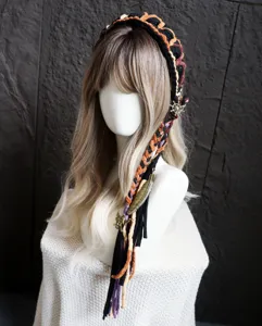 Vista dettagliata della fascia boho fatta a mano all'uncinetto con nappe colorate e ciondoli.