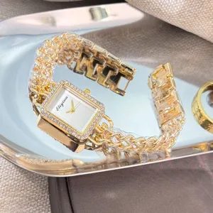 Detailansicht der goldenen Damenuhr mit Strass-Quadratgehäuse und doppeltem Kettenarmband.