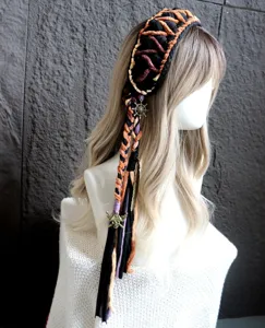 Dettaglio fascia per capelli all'uncinetto fatta a mano, design bohémien con ciondoli.