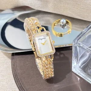 Detailansicht der goldenen rechteckigen Damen Quarzuhr mit Strass und Doppelarmband.